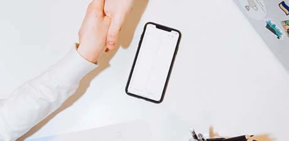 Handshake beside a smartphone during a business meeting